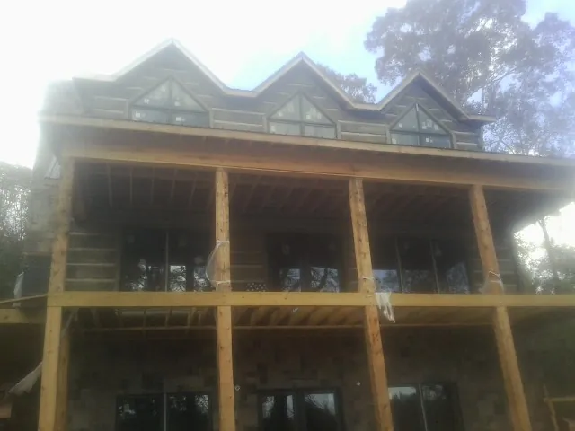 Dormers and porch framing on a large log home under construction — Roof Coating work by our crew in Hummelstown