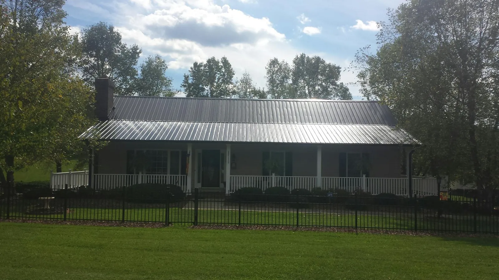 Gray metal roof on a brick ranch with a full width front porch — Gutter Guard Installation work by our crew in Hummelstown